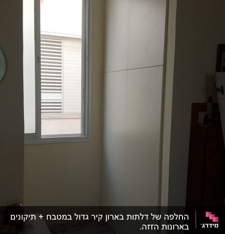 ארון עץ לבן ליד חלון גדול